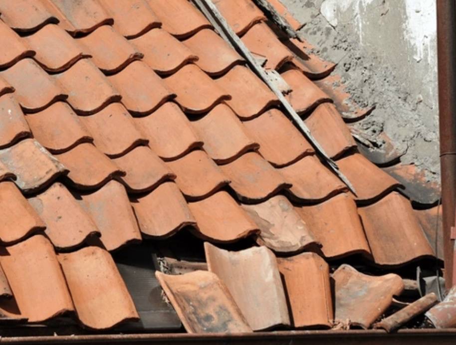 Storm-damaged clay roof tiles needing repair